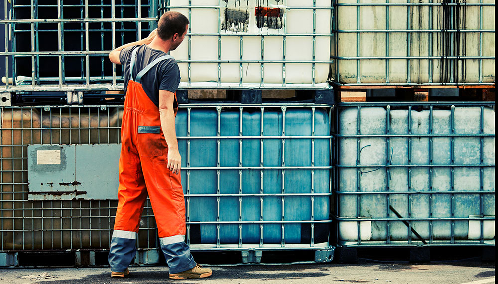 werkman inspecteert vloeistofcontainers