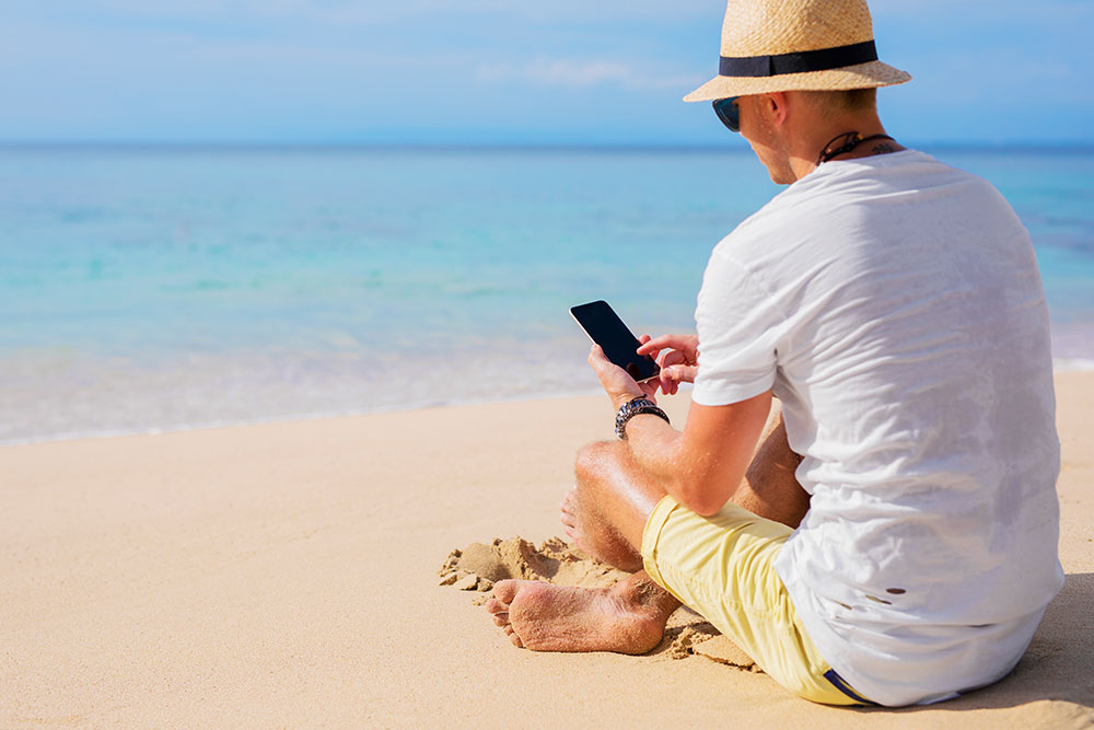 man met smartphone op het strand