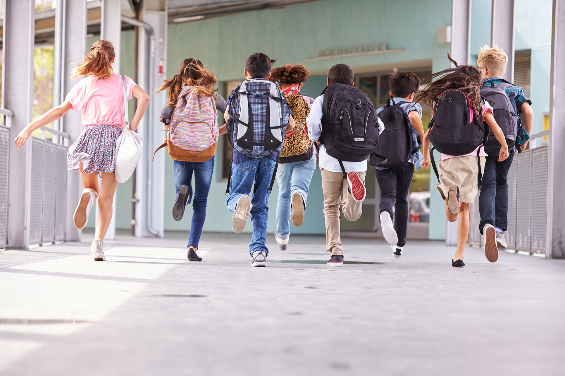 kinderen met boekentassen lopen weg