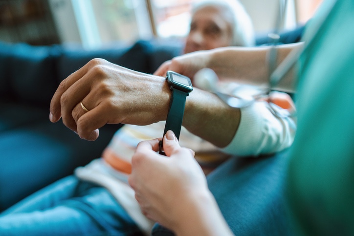 verpleegkundige bevestigt wearable bij senior