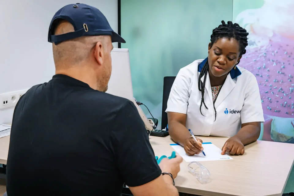 Vrouwelijke arbeidsarts in medisch kabinet met arbeider